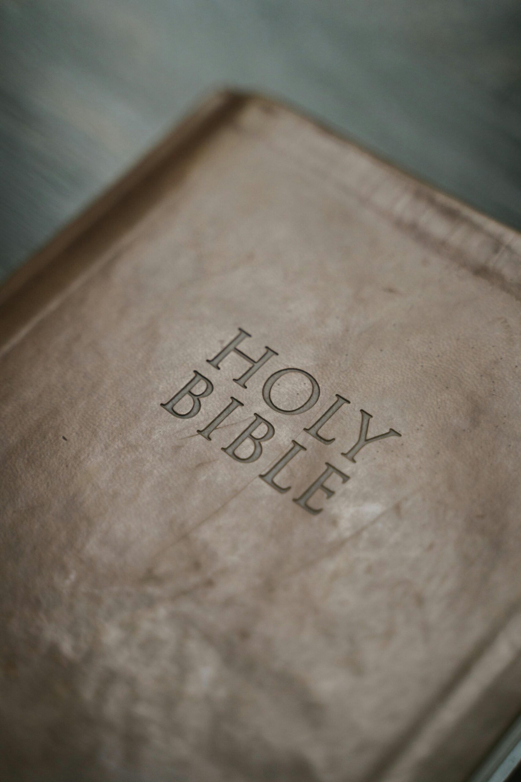Detailed close-up shot of an antique Holy Bible cover, highlighting texture and design.